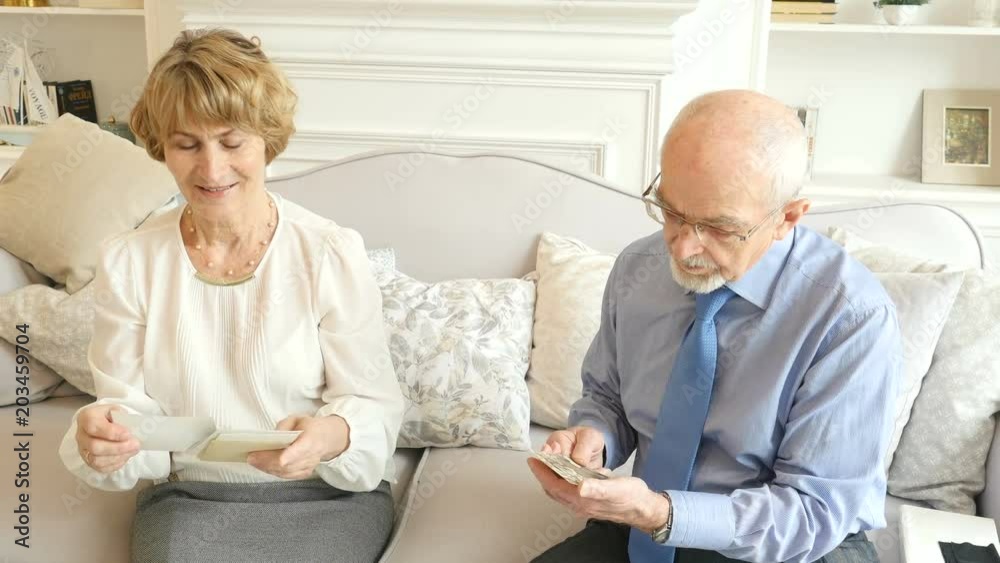 Portrait of happy attractive elderly couple watching old photos Portrait of happy attractive elderly couple watching old photos