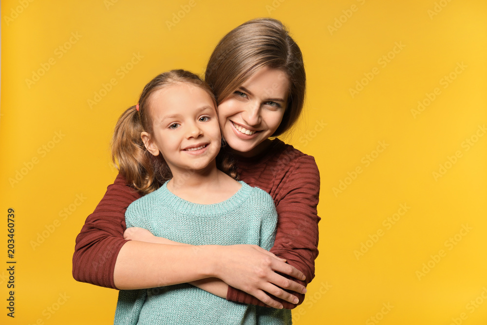 Portrait of mother and cute little daughter on color background Portrait of mother and cute little daughter on color background
