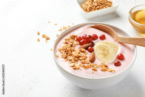 Bowl with delicious yogurt and granola on table