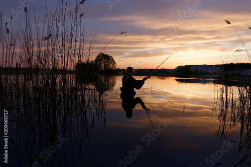 Fisherman at the lake during sunset