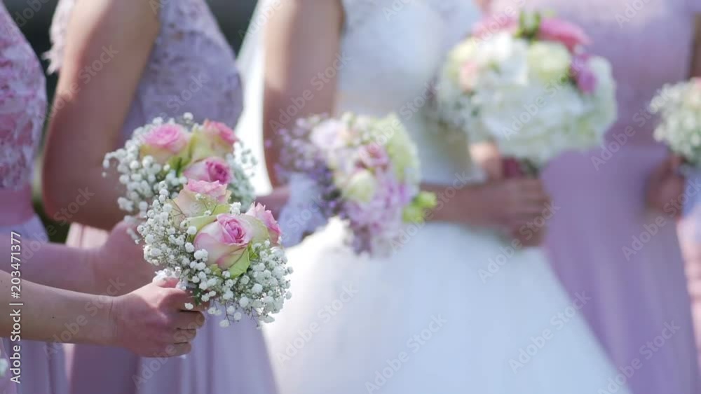 A bride and bridesmaids in pink dresses holding their bouquets. A bride and bridesmaids in pink dresses holding their bouquets.