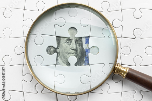 Magnifier and puzzle on money. 