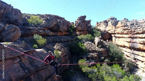 Male highliner walkng on a rope over rocky mountains  photo