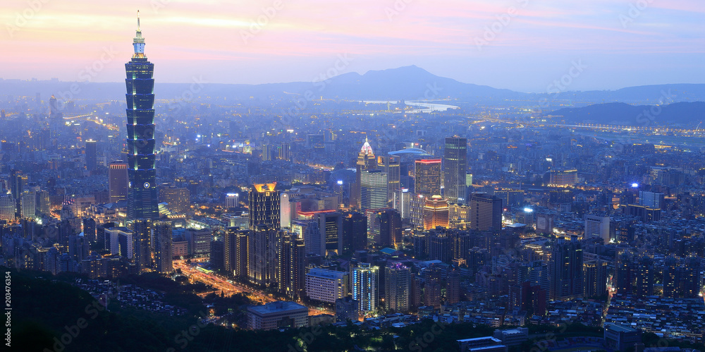 Aerial panorama of busy Taipei City at dusk, with a view of Taipei buildings in downtown area and Tamsui River and distant mountains in the background ~ A Blue and Gloomy evening scenery of Taipei