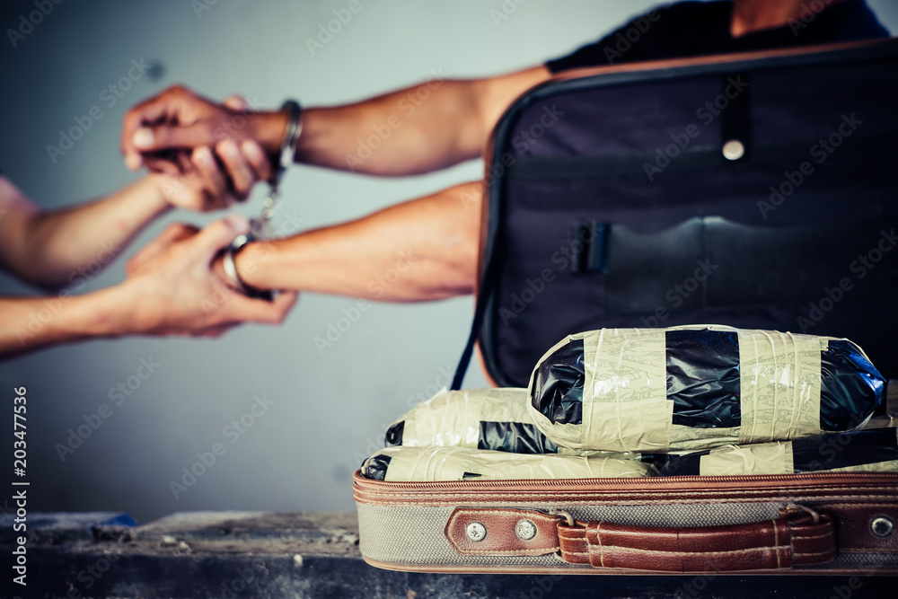 Law and police concept. Police arrest drug trafficker with handcuffs. Law and police concept. Police arrest drug trafficker with handcuffs.