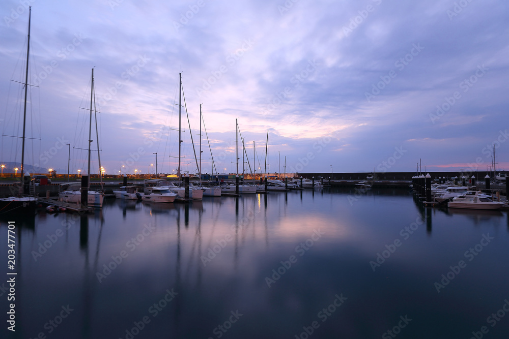 Beautiful scenery of fishing boats and yachts parking in marina under stormy sky in I-lan, Taiwan ~ Dramatic moody sky at sunrise by the beach before an oncoming storm 