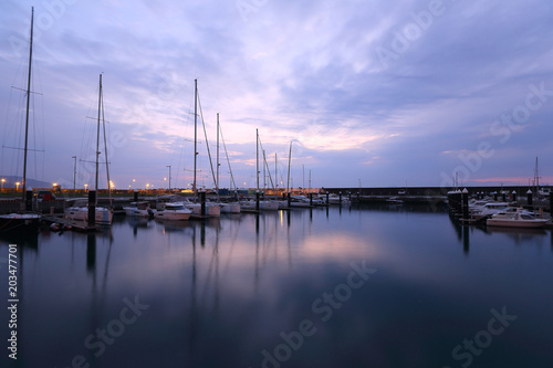 Beautiful scenery of fishing boats and yachts parking in marina under stormy sky in I-lan, Taiwan ~ Dramatic moody sky at sunrise by the beach before an oncoming storm 