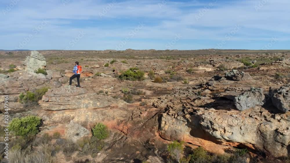 Male rock climber walking over a rocky mountain Male rock climber walking over a rocky mountain