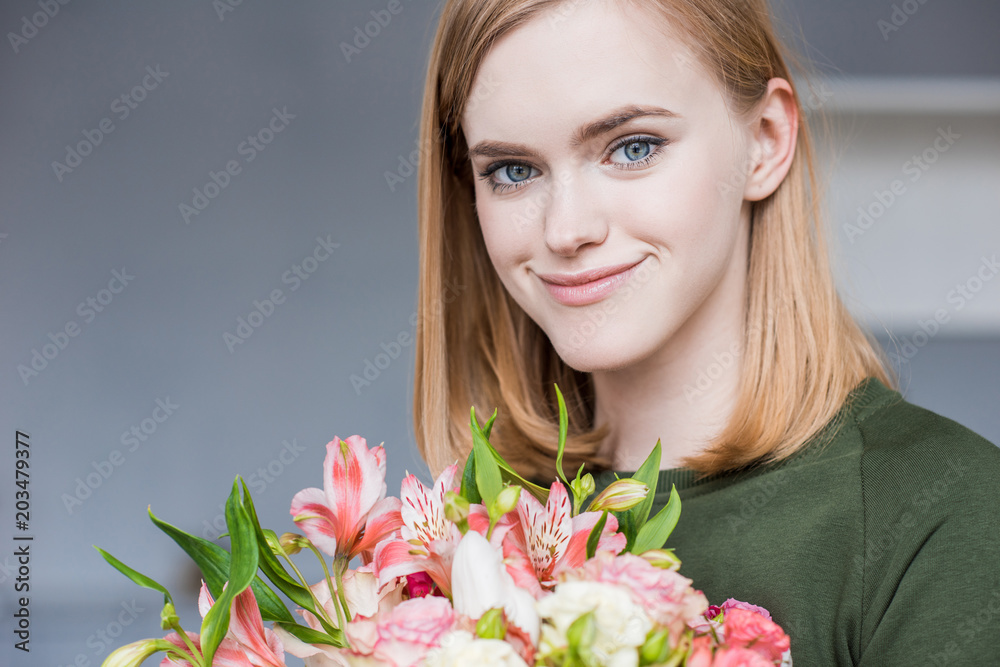 portrait of young smiling woman holding bouquet of flowers portrait of young smiling woman holding bouquet of flowers