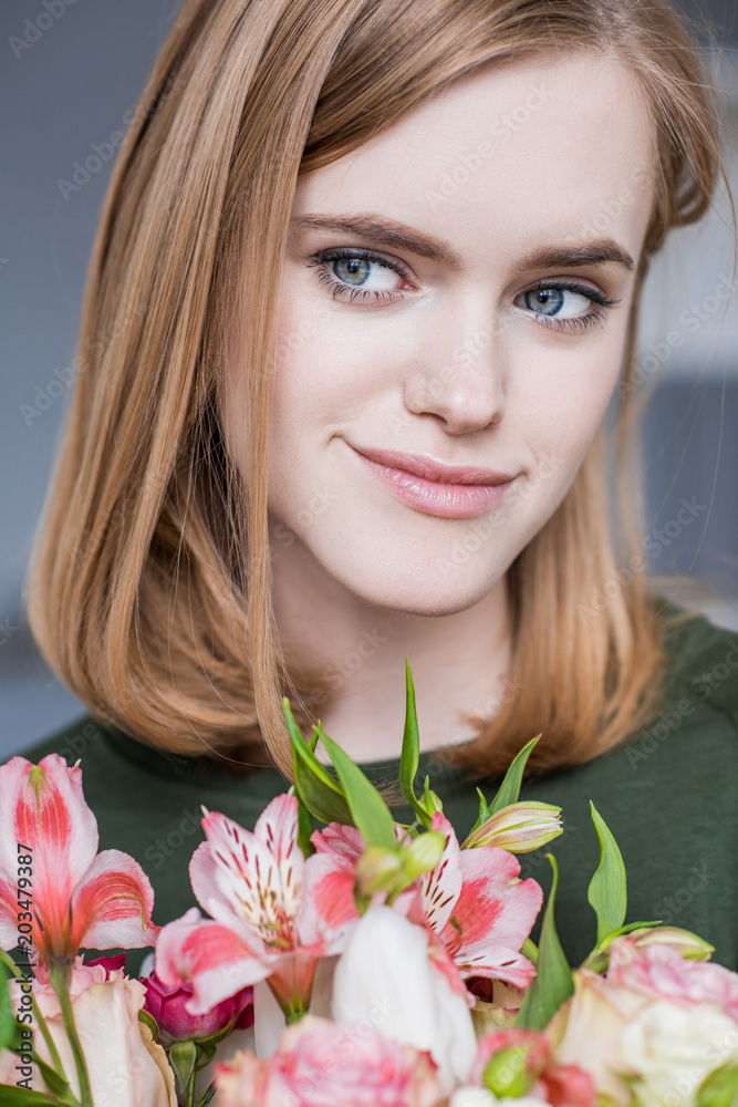 portrait of young woman with bouquet of alstroemeria portrait of young woman with bouquet of alstroemeria