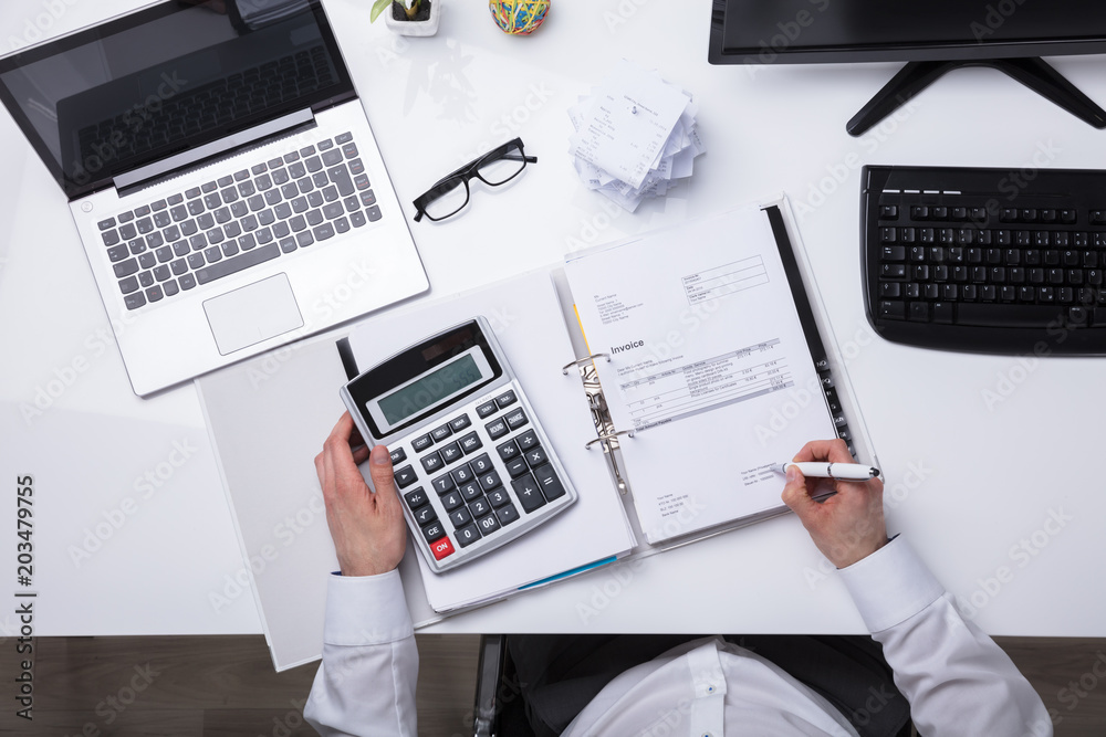 High Angle View Of A Businessperson Calculating Bill High Angle View Of A Businessperson Calculating Bill