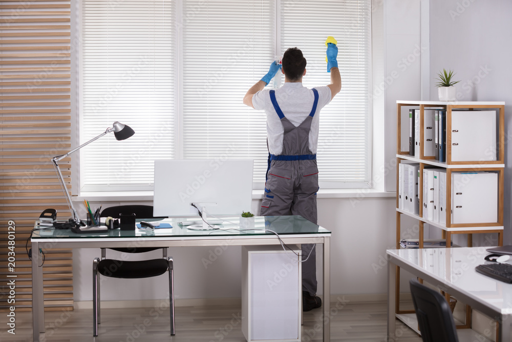 Male Worker Cleaning Window Blinds With Sponge Male Worker Cleaning Window Blinds With Sponge