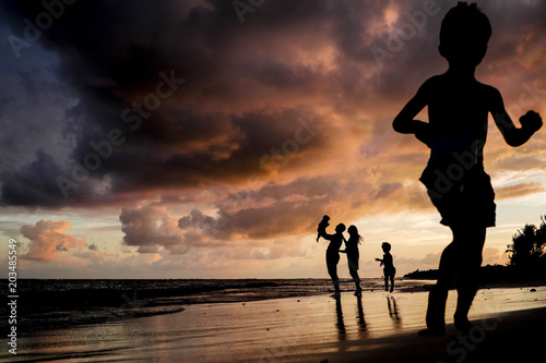 Family with three kids having fun on the beach in Mexico