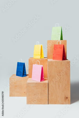 blue, yellow and green shopping bags on wooden stands, summer sale concept
