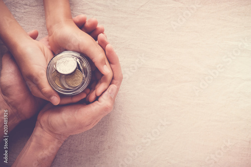child and adult holding money jar, donation, saving, charity, family finance plan concept, fundraising, superannuation, inflation recession concept