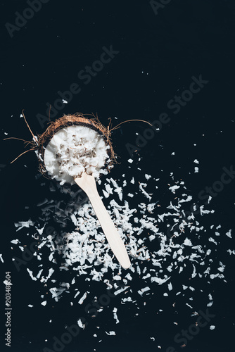 close-up view of fresh organic coconut with shavings on black