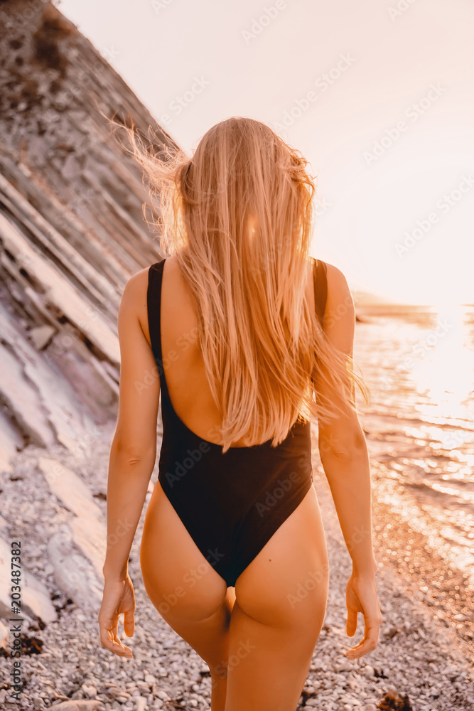 Blonde beautiful woman with perfect body in bikini with sunset colors. Blonde beautiful woman with perfect body in bikini with sunset colors.