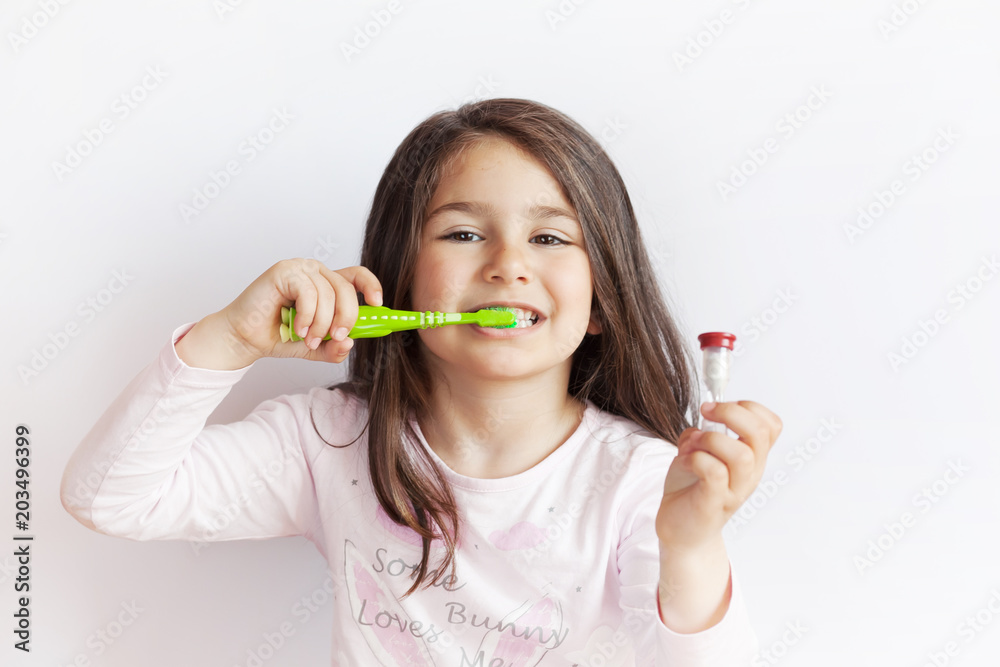 Little cute child girl brushing her teeth on white background. Space for text. Healthy teeth. Little cute child girl brushing her teeth on white background. Space for text. Healthy teeth.
