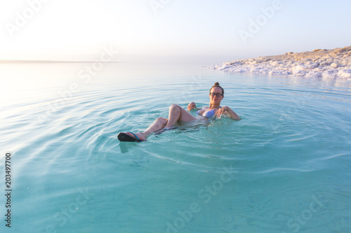 Woman swimming in salty water of a Dead Sea © vitek5g