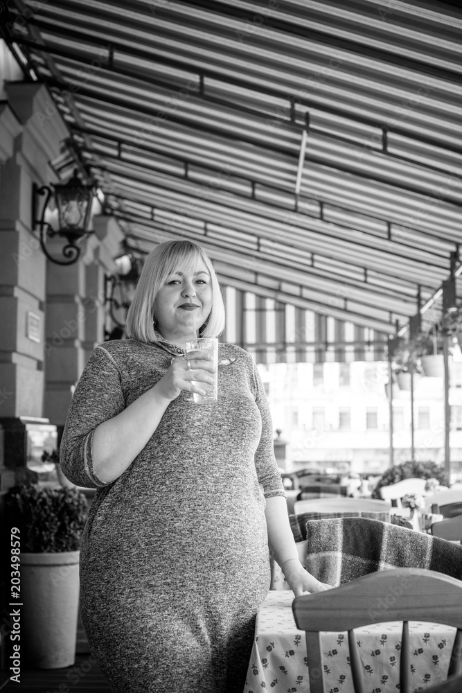 Obraz premium Happy smiling fashionable plus size young woman in modern city life. Life of xxl lady. Concept of positive lifestyle. Pretty stylish girl at city center