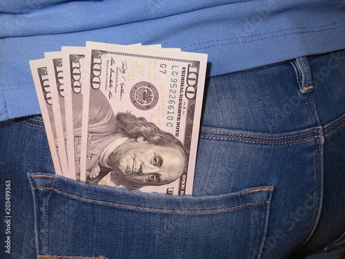 US dollars in the back pocket. Money in woman's jeans pocket