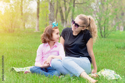 mom and daughter have a rest on the nature on green grass photo