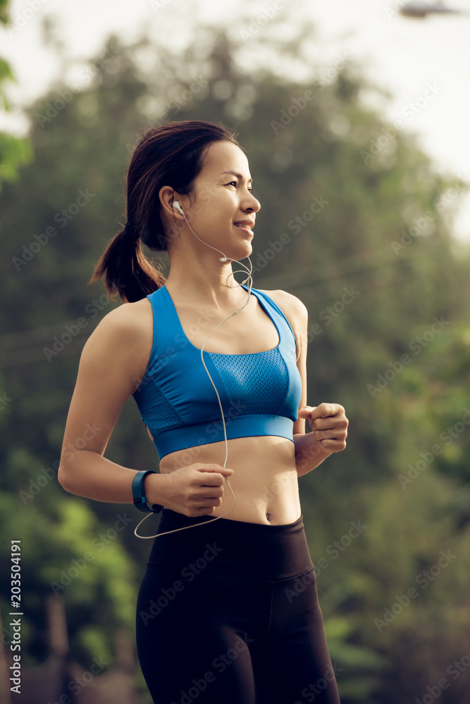 Fototapeta premium young sports woman runner running on road
