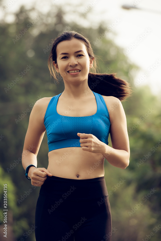 Fototapeta premium young sports woman runner running on road