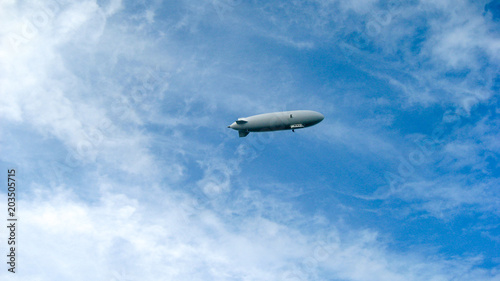 Zeppelin in front of blue sky, some clouds with airship photo