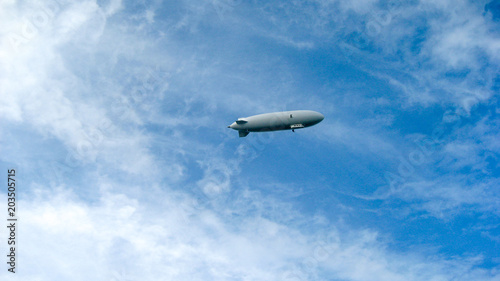 Zeppelin in front of blue sky  some clouds with airship