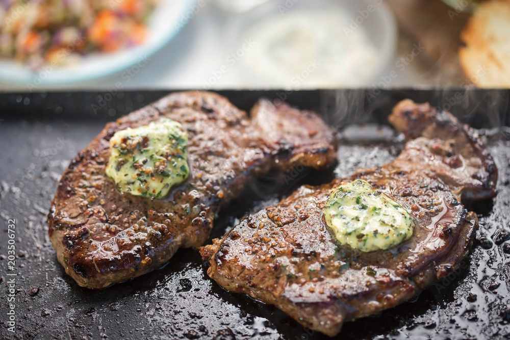 Angus steaks with garlic butter on barbecue with salad and dips. Barbecue party Angus steaks with garlic butter on barbecue with salad and dips. Barbecue party