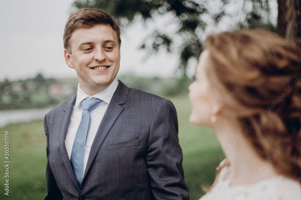 Happy newlywed groom looking at his bride, married couple portrait, handsome groom smiling near beautiful bride Happy newlywed groom looking at his bride, married couple portrait, handsome groom smiling near beautiful bride