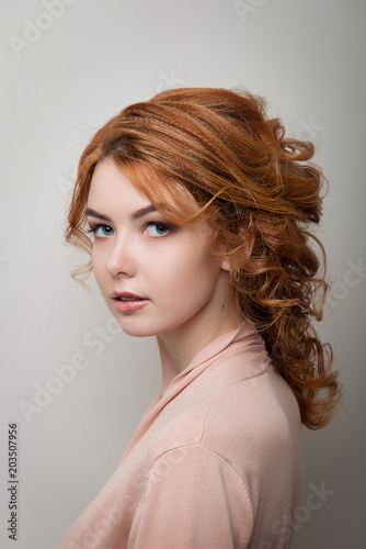 Red-haired girl with hairstyle Greek braid and professional make-up on white isolated background close-up.