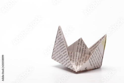 Origami paper boat isolated on white background