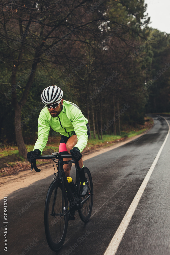 Sportsman riding bicycle on country highway Sportsman riding bicycle on country highway