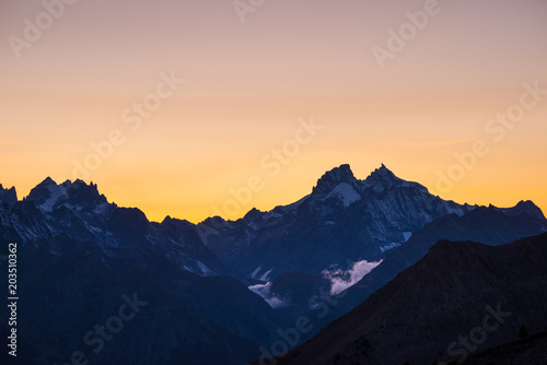 High altitude alpine landscape at dawn with first light glowing the majestic high peak of the Barre des Ecrins (4101 m), France.