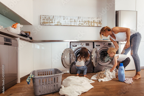 Obraz na plátně Family doing laundry together at home