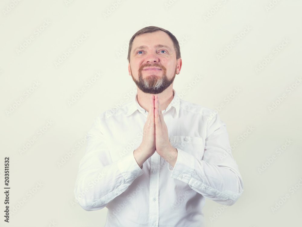 Pray. An adult happy man with a beard in prayer holds his hands in front of him. Pray. An adult happy man with a beard in prayer holds his hands in front of him.