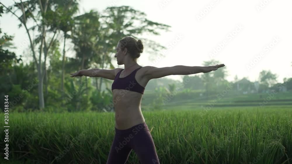 Young girl practice extended triangle yoga pose at rice fields rapid slow motion Young girl practice extended triangle yoga pose at rice fields rapid slow motion