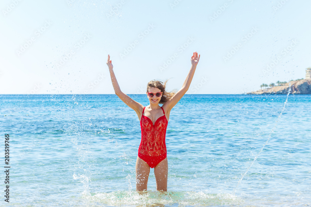 Beautiful happy girl in splashing water on vacation Beautiful happy girl in splashing water on vacation