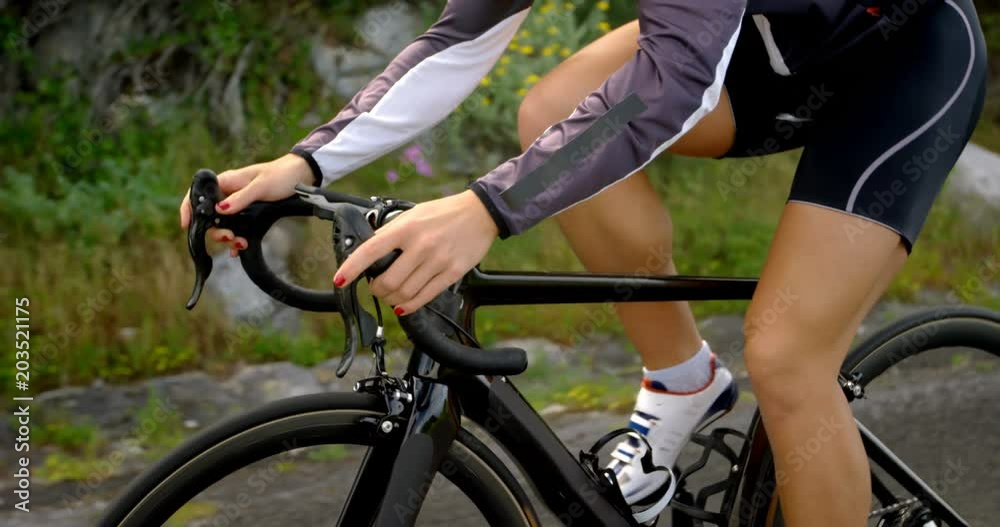 Female cyclist cycling on a countryside road Female cyclist cycling on a countryside road