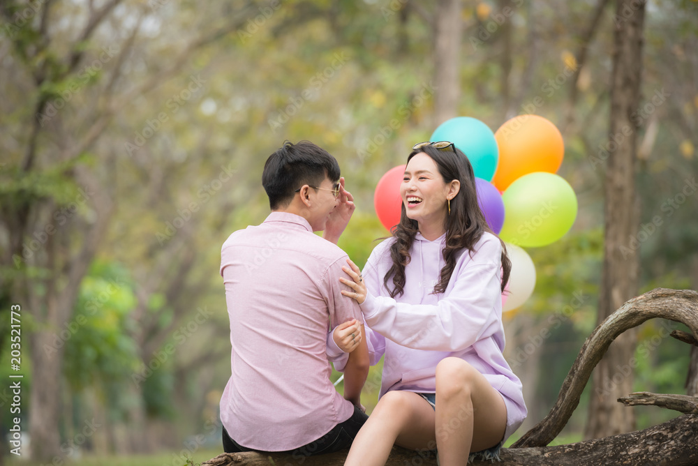 Fototapeta premium A boyfriend and girlfriend reading a book in park