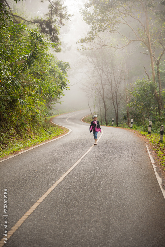 A little girl run on a road in the forest A little girl run on a road in the forest