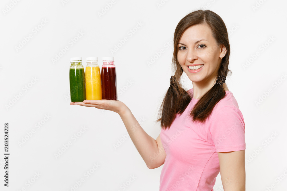 Fun woman holds row of green, red, yellow detox smoothies in bottles isolated on white background. Proper nutrition, vegetarian drink, healthy lifestyle, dieting concept. Copy space for advertisement. Fun woman holds row of green, red, yellow detox smoothies in bottles isolated on white background. Proper nutrition, vegetarian drink, healthy lifestyle, dieting concept. Copy space for advertisement.