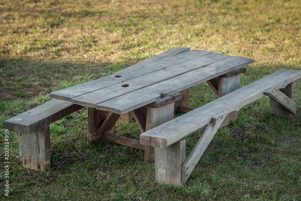 Vintage wooden table with benches in nature.