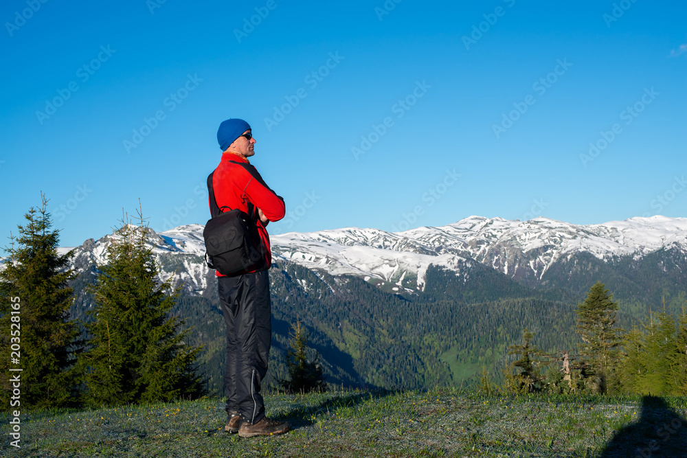Dreaming adventurer, photographer is standing on the mountain slope