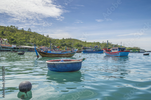 fishing boats, junks in the sea bay near the island of Vinperl, amidst the islands covered with tropical vegetation and blue sky, Vietnam