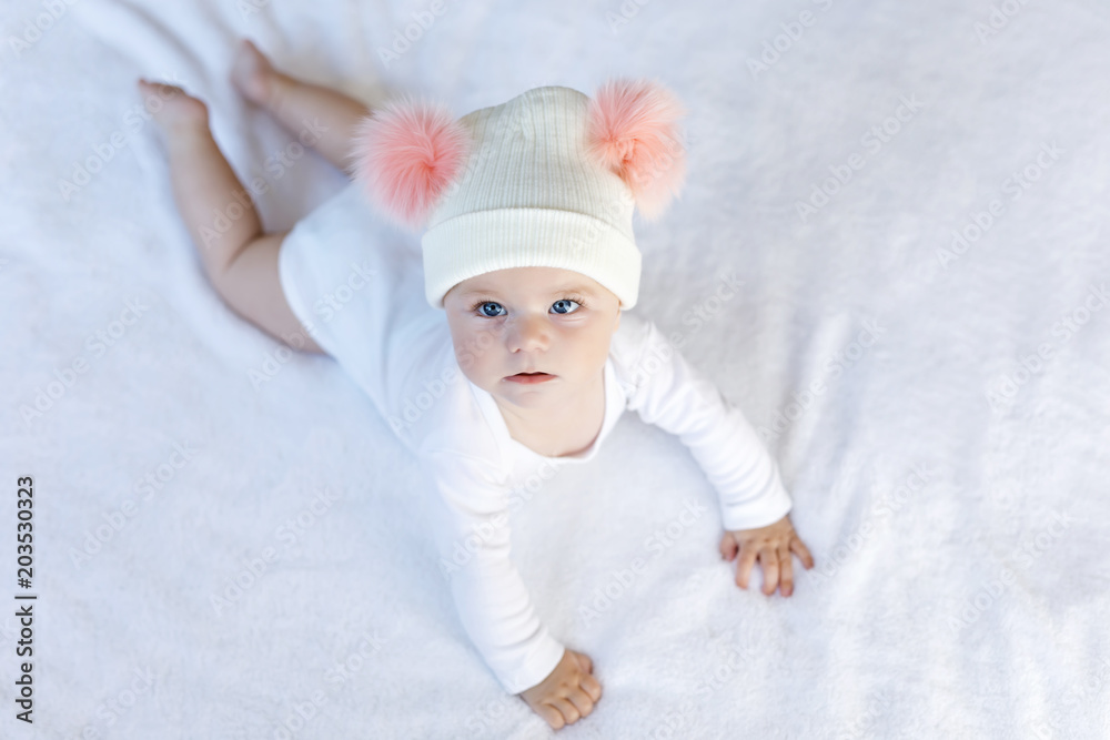 Cute adorable baby child with warm white and pink hat with cute bobbles Cute adorable baby child with warm white and pink hat with cute bobbles