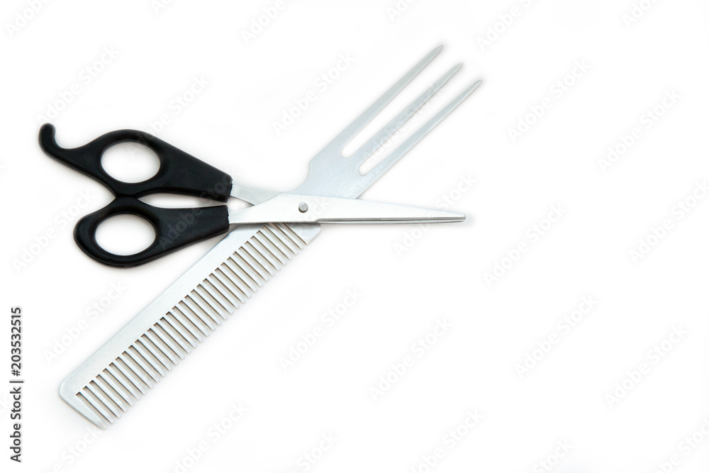 Hairdressing scissors with black handles and a metallic shiny comb on a white background. Close image. Hairdressing scissors with black handles and a metallic shiny comb on a white background. Close image.