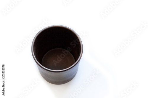 Empty ceramic clay cup on a white background. View from above.